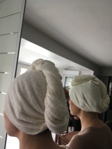 Serviette écrue installée sur tête, prise devant un miroir