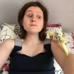 Camille assise sur un canapé avec un oiseau sur son bras gauche