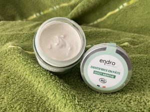 Pâte de dentifrice dans un pot en verre, avec couvercle à côté