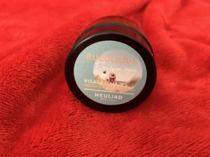 Petit pot de crème en verre sur fond rouge